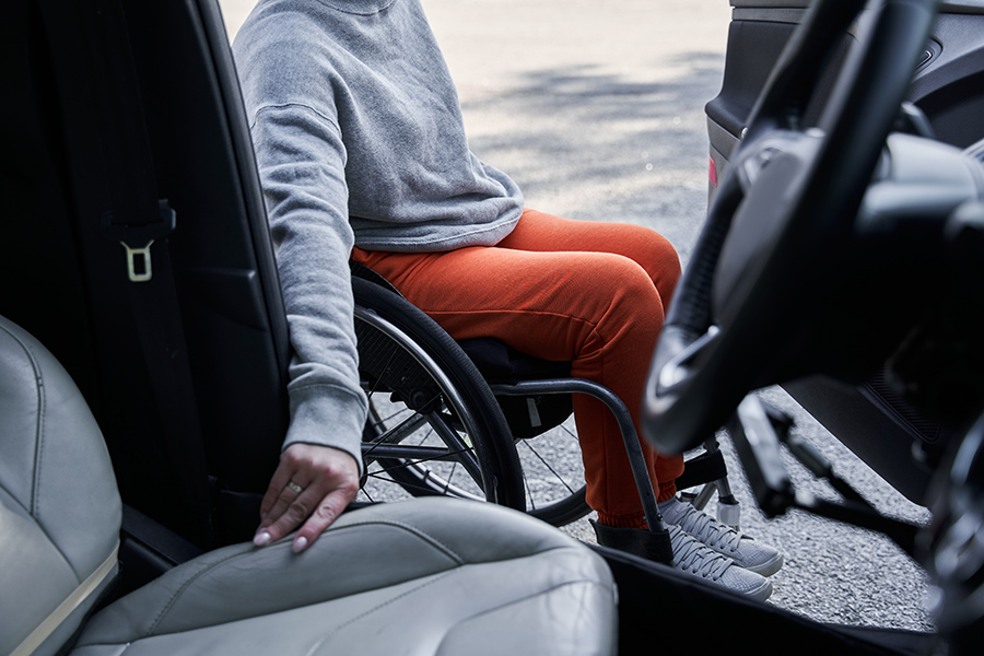 man in wheelchair getting into a car